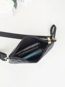 Detail view showing interior capacity and monogram design of the black cross-body bag.