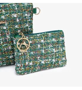 Green tweed cosmetic bag set with metallic keychain, elegant plaid texture detail view.