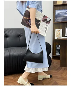 Detailansicht einer eleganten schwarzen Schultertasche in einem modernen Innenbereich.