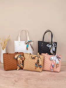 Detailansicht von fünf farbigen Shoppern mit feiner Steppung und eleganten Seidenschals.