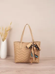 Detailansicht der beigen gesteppten Tasche mit Zickzackmuster und elegantem Seidentuch.