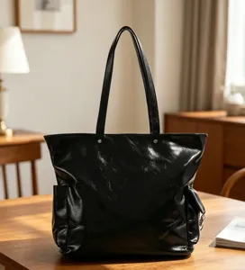 Vue détaillée du sac cabas noir brillant et élégant sur une table en bois avec texture.