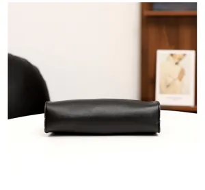 Detaillierte Bodenansicht einer eleganten schwarzen Ledertasche mit feiner Verarbeitung.