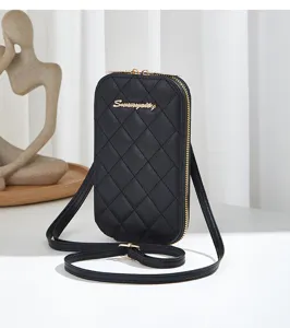 Detalle del elegante bolso bandolera para móvil negro acolchado con textura fina.