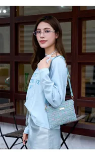 Close-up detail of the blue tweed crossbody bag showing textured fabric and gold hardware.