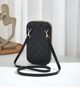 Vista detallada de un elegante bolso bandolera acolchado negro con cremalleras doradas.