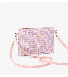 Pink tweed crossbody bag detail, featuring textured fabric and elegant gold-tone hardware.