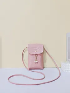 Detailweergave van een roze krokodillenpatroon telefoon tas met elegante parelkwast hanger.