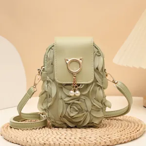 Detailaufnahme einer salbeigruenen Mini Handytasche mit Stoffrosen und Perlenanhaenger.