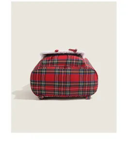 Detail shot of the red plaid backpack featuring fluffy white sherpa trim and classic winter design.