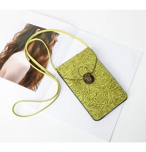 Borsa a tracolla per telefono in pelle goffrata verde con chiusura vintage e cinturino.
