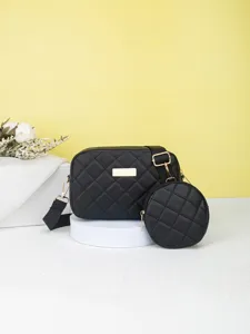 Black quilted cross body bag detail showing soft texture, gold hardware and round coin pouch.