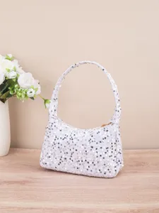 Detailopname van de witte pailletten tas met sprankelende textuur en handige rits.