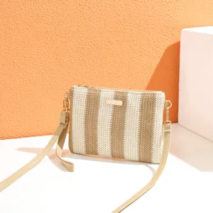 Detail view of woven striped crossbody bag, beige and brown straw shoulder bag detail.