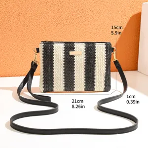 Black and white striped straw crossbody bag with shoulder strap and metal hardware detail.