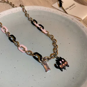 Close-up detail of the black anime creature pendant necklace with pink crystals and mixed chain.
