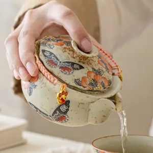 Théière en céramique chinoise pour thé Gongfu, avec un design élégant de pêche et papillon.