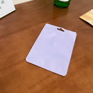 Vista di dettaglio della bustina in plastica viola pastello con pratico foro per appendere.