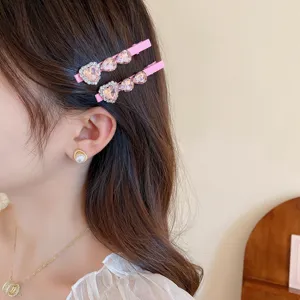 Detailopname van een schattige roze strass hart haarspeld aan de zijkant van het haar gedragen.