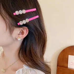 Charmante detailafbeelding van de roze strass eendebek haarklem met sprankelend kristalontwerp.