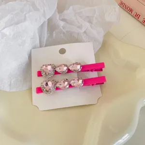 Gedetailleerde opname van schattige roze strass hart eendensnavel haarspelden met glitters.