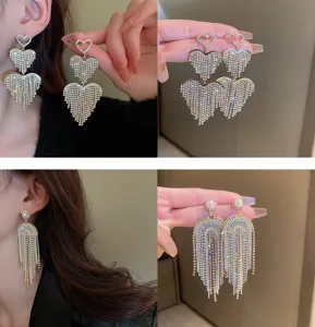 Detailed view of exquisite rhinestone heart and pearl arch tassel earrings sparkling crystals.