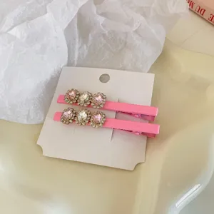 Detailopname van roze haarspelden met fonkelende kristallen, zoet en stijlvol ontworpen.