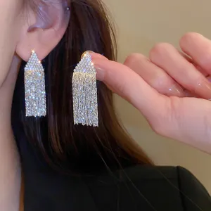 Close up view of the sparkling rhinestone geometric tassel earrings showcasing detail.