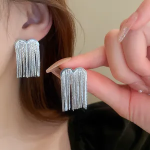 Silver heart fringe tassel earrings detail shot, stylish geometric metallic drop design for women.