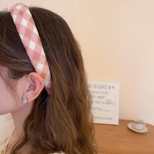 Vista dettagliata della fascia per capelli imbottita a quadri rosa, accessorio trendy.