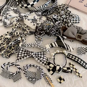 Nahaufnahme der stilvollen schwarz-weißen Karo- und Hahnentritt-Haaraccessoires-Kollektion.