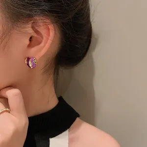 Close-up detail shot of the French retro purple fashion ear studs worn on ear.