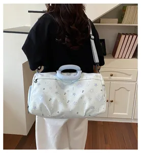 Detailed view of casual light blue travel duffel bag with cute star and bow patterns.