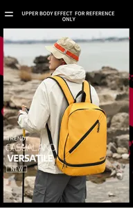 Outdoor detail shot of a bright yellow casual backpack worn by a model on a rocky beach.