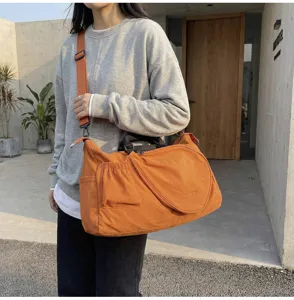 Dettaglio borsa da viaggio sportiva arancione, elegante design a tracolla e borsa a mano.