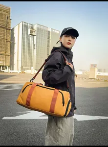 Outdoor travel duffel bag detail, large capacity yellow sports bag with durable shoulder straps.