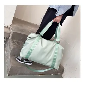 Light green travel duffel bag detail showcasing sturdy handles and adjustable strap design.