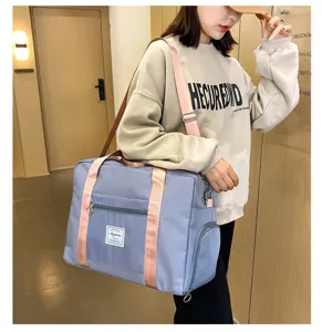 Detail view of large capacity travel duffel bag with shoe compartment and pink straps.