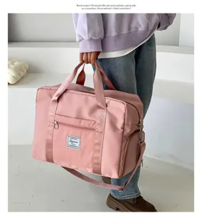 Large capacity pink travel duffel bag for women, featuring shoulder strap and front pocket.
