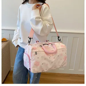 Pink travel duffel bag detail showing star pattern design, large capacity and strap.