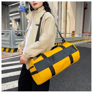 Detail shot of large capacity yellow gym duffel bag with black straps for travel sports.