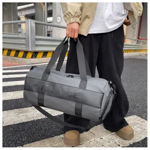 Grey gym duffel bag detail, large capacity sports travel bag with shoulder strap.