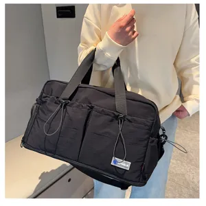 Detail view of a black multi-pocket travel duffel bag for fitness and casual daily use.