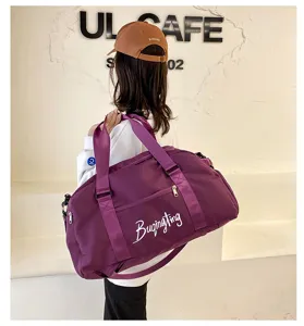 Vue détaillée du sac de voyage violet en toile, montrant le porté épaule et le style.