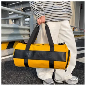 Detailed closeup view of yellow and black sports fitness duffel bag in outdoor street scene.