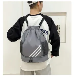 Detailed view of grey drawstring sports backpack with shoe compartment and three stripe design.
