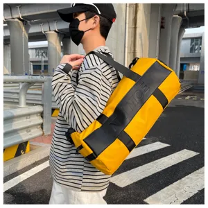 Cylindrical gym travel duffel bag in bright yellow with black straps and embossed details.