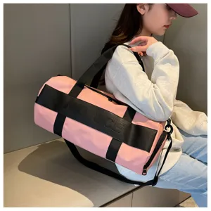 Detailed shot of the pink gym duffel bag with black straps, showing large capacity.