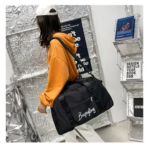 Vue détaillée du sac de voyage de sport noir en nylon avec bandoulière et imprimé élégant.