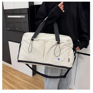 Canvas travel duffel bag detail, large capacity gym bag with front pockets and straps.